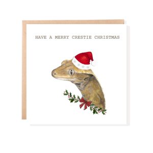 Crested Gecko Christmas card with colour pencil drawing of a gecko in a Santa hat on a white background with text